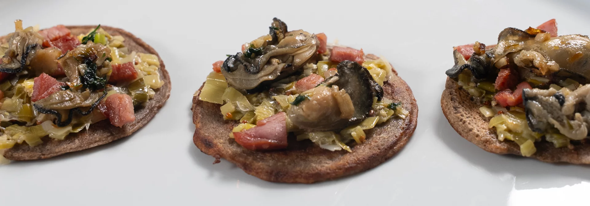 Recette : Galette aux huîtres snackées, fondue de poireaux et bacon